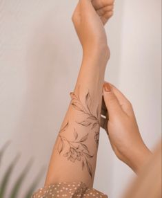 a woman's arm with a flower tattoo on it and a polka dot dress