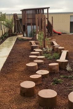 there is a playground in the back yard with wooden benches and logs on the ground