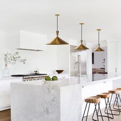 a kitchen with marble counter tops and stools