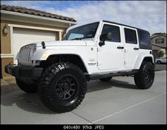 a white jeep parked in front of a house