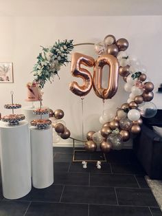 balloons and decorations are arranged on the floor in front of a 50th birthday balloon arch