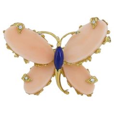 This vintage Fred Paris butterfly brooch from the 1970s is crafted from 18k gold and features a striking combination of Mediterranean coral and lapis lazuli. The wings are made of delicately light colored coral, while the body is crafted from lapis lazuli, creating a vibrant contrast. Diamond accents add an extra touch of elegance to this beautifully detailed piece. The brooch weighs 14.3 grams, measuring 1 1/8 inches in height and 1 1/2 inches in width. It is stamped with the FRED signature, the French essay eagle mark, and a maker's mark, confirming its authenticity. This brooch captures the creativity and craftsmanship Fred Paris is known for, making it a unique addition to any vintage jewelry collection. Butterfly Brooch, Vintage Butterfly, Maker's Mark, The 1970s, Makers Mark, Lapis Lazuli, Brooch Pin, Vintage Jewelry, Jewelry Collection