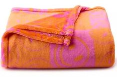 an orange and pink blanket on top of a white surface with circles drawn on it