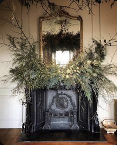 the fireplace is decorated with greenery and flowers