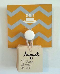 a birthday card hanging on a wall with a cake and candles in it, next to a sign that says august