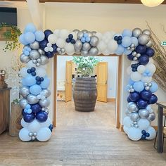 an archway decorated with blue and silver balloons