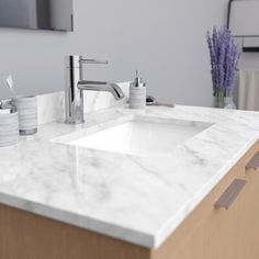 a bathroom sink with two toothbrushes and soap dispensers