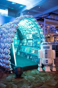 an inflatable droid and r2d2 stand next to each other