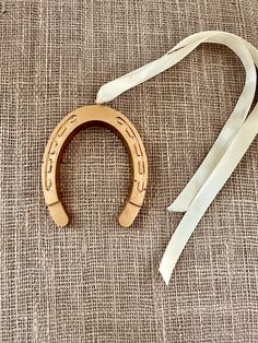 a pair of wooden stirs sitting on top of a piece of cloth next to a white ribbon