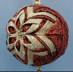 a red and gold ornament hanging from a hook