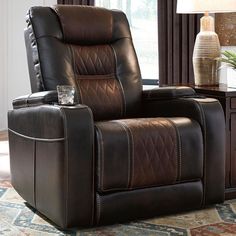 a brown recliner chair sitting on top of a rug