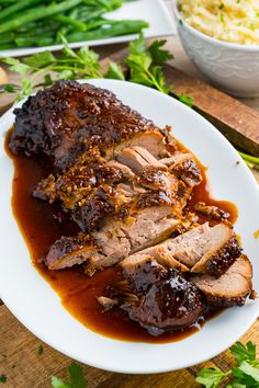 a plate with meat covered in sauce and garnished with parsley on the side