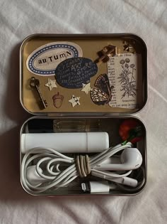 an open tin box with various items in it