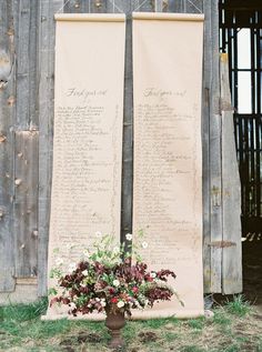 a vase filled with flowers on top of a grass covered field next to an old wooden fence