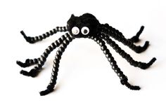 a close up of a black spider made out of beads with eyes on it's head