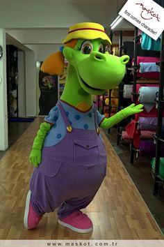 a green and purple dragon mascot standing in a store