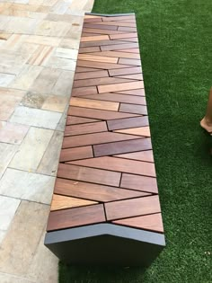 a wooden bench sitting on top of a lush green grass covered park area next to a brick walkway