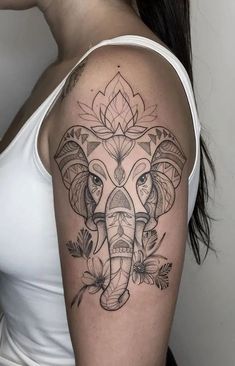 an elephant tattoo on the right arm and shoulder, with leaves around its head in front of it