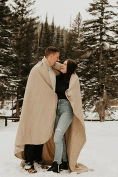 a man and woman standing next to each other in the snow