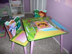 two children's table and chairs with dora the explorer theme on them in a purple room