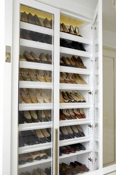 an open closet with many pairs of shoes in it