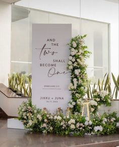 a wedding sign with flowers and greenery on the front of it, next to some stairs