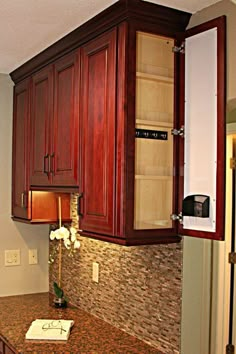 a kitchen with wooden cabinets and granite counter tops on the wall, along with a microwave oven