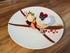 a white plate topped with desserts on top of a wooden table