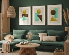 a living room with green couches and pictures on the wall above them in shades of teal