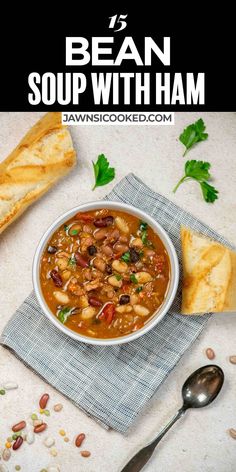 bean soup with ham in a white bowl on top of a blue napkin next to bread