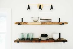 two wooden shelves with plates and cups on them