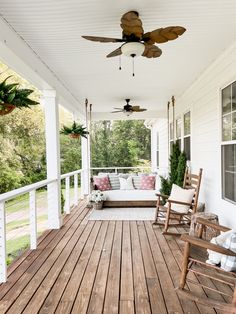 a porch with rocking chairs and a ceiling fan