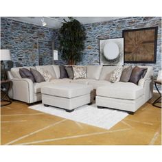 a living room filled with furniture next to a wall covered in stone and rugs