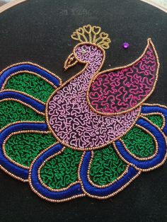 an embroidered peacock on a black background