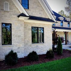 a white brick house with black trim and windows