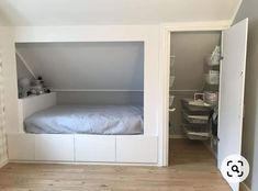 an empty room with a bed in the corner and shelves on the wall behind it