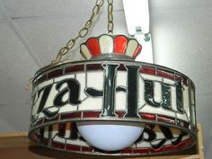 a stained glass lamp hanging from the ceiling in a room with a sign on it