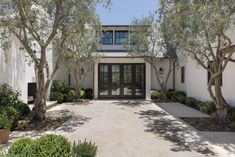 an entrance to a home with trees and bushes