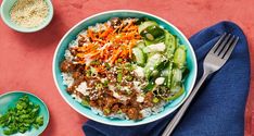 a bowl filled with rice, meat and veggies on top of a table