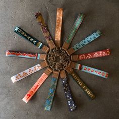 a group of different colored bracelets arranged in a circle on the ground with words written across them