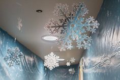 snowflakes are hanging on the wall in this hallway decorated with blue and white