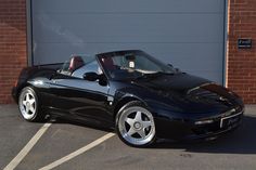 a black sports car parked in front of a garage