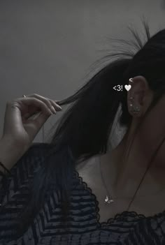 a woman with her hair blowing in the wind and wearing ear piercings on her ears