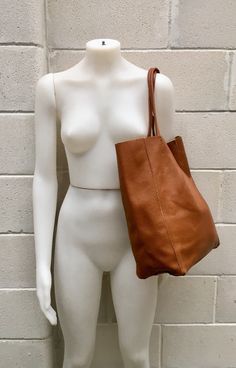 Large tote leather bag in dark CAMEL BROWN. Saddle brown shoulder bag. Tan color natural GENUINE leather. Large enough for books or a laptop, tablet, cosmetics bag etc. Leather shopper. The inside of the bag is not lined (although properly finished!) . We added a small leather pouch on the inner part of the bag (4th pic) The bag can be closed by 2 leather straps attached to each side. Excellent quality soft but strong genuine leather. Width upper part: 41cm - 16 inch Height: 38 cm - 15 inch This Dark Tan Leather Bag For On-the-go, Casual Cognac Shoulder Bag With Leather Handles, Camel Tote Shoulder Bag With Leather Handles, Brown Bags With Leather Lining For Everyday Use, Brown Satchel With Leather Handles For Shopping, Brown Leather Lined Everyday Bag, Cognac Tote Shoulder Bag For Shopping, Brown Leather Lining Bags For Everyday, Brown Double Handle Shoulder Bag For Everyday