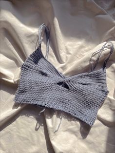 a knitted bra laying on top of a white sheet