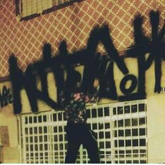 a man riding a skateboard down the side of a wall covered in graffitti