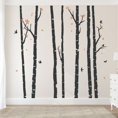 a bedroom with white walls and trees painted on the wall