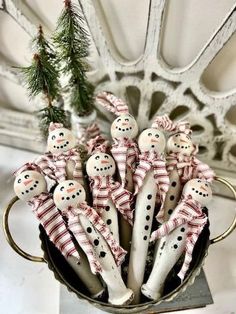 a group of snowmen sitting in a metal container on top of a white table