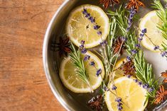 lemons, rosemary, and lavender in a pan on a wooden counter top with spices