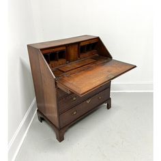 an old wooden desk with two drawers on the top and one drawer open to show what's inside